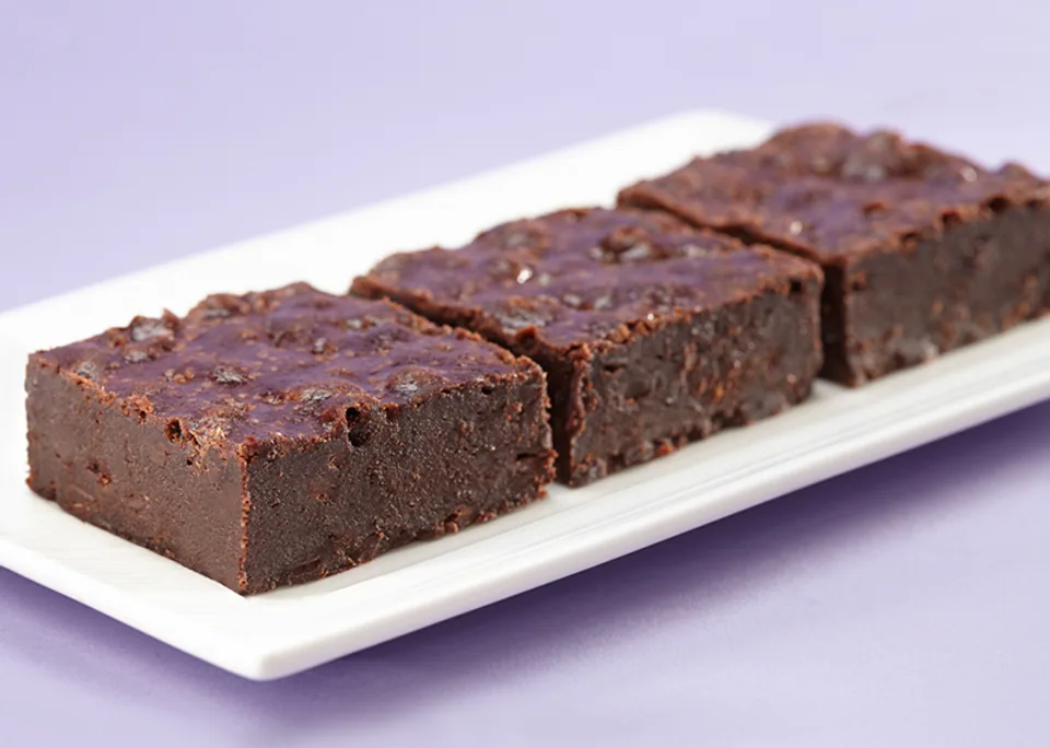 Three fudgy brownies on a white plate